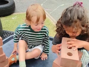 Children stacking foam bricks outside