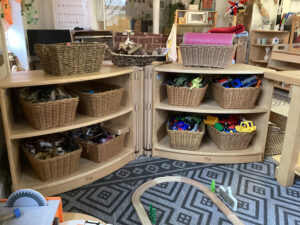 Shelves next to a wooden trainset on a carpet in the pre-school room